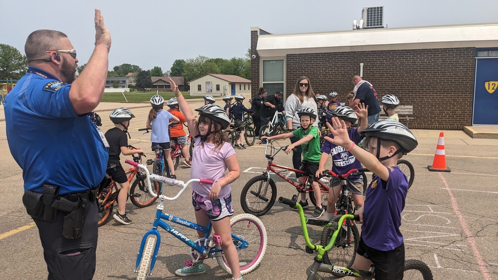 Officer Witt teaching bike safety at Bike Rodeo with second grade students